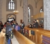 Gemeindeglieder nehmen Platz in der neu renovierten Kirche